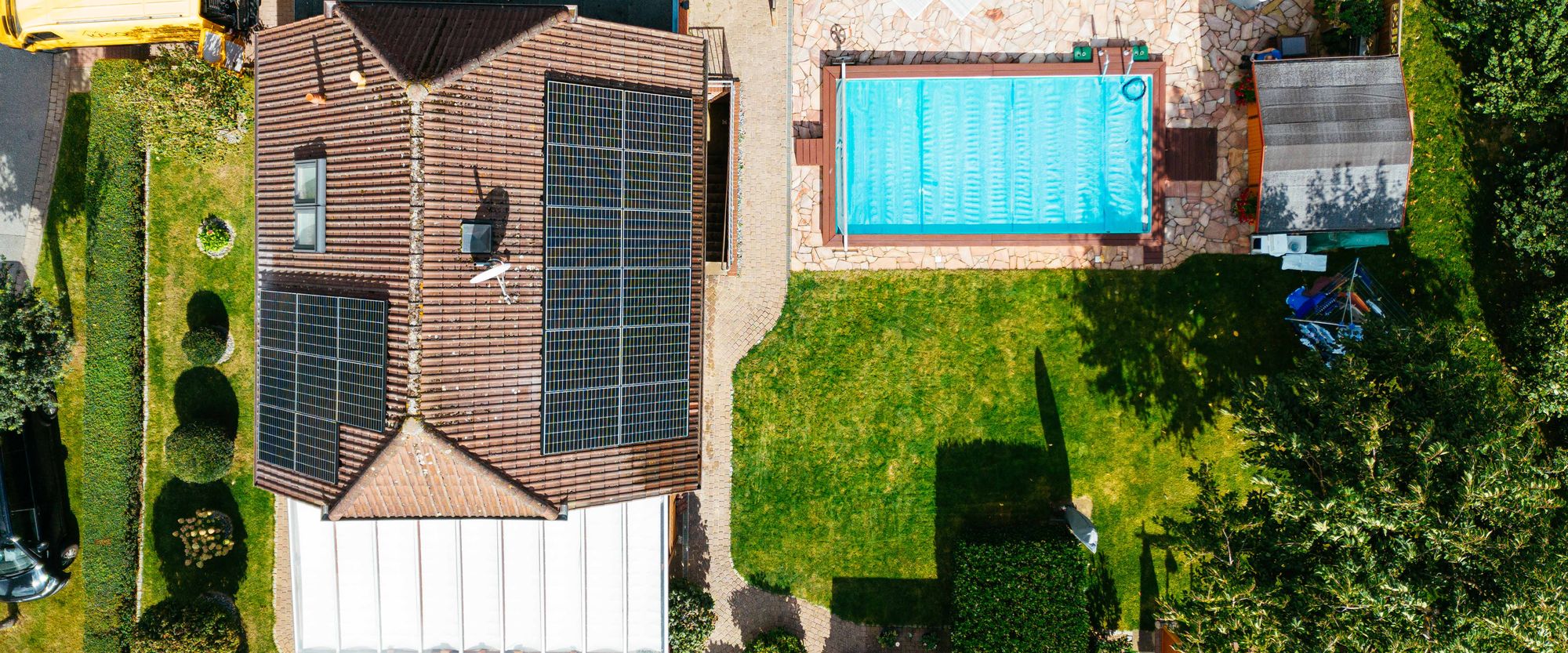 Drohnenaufnahme eines Hauses mit Photovoltaik und Pool